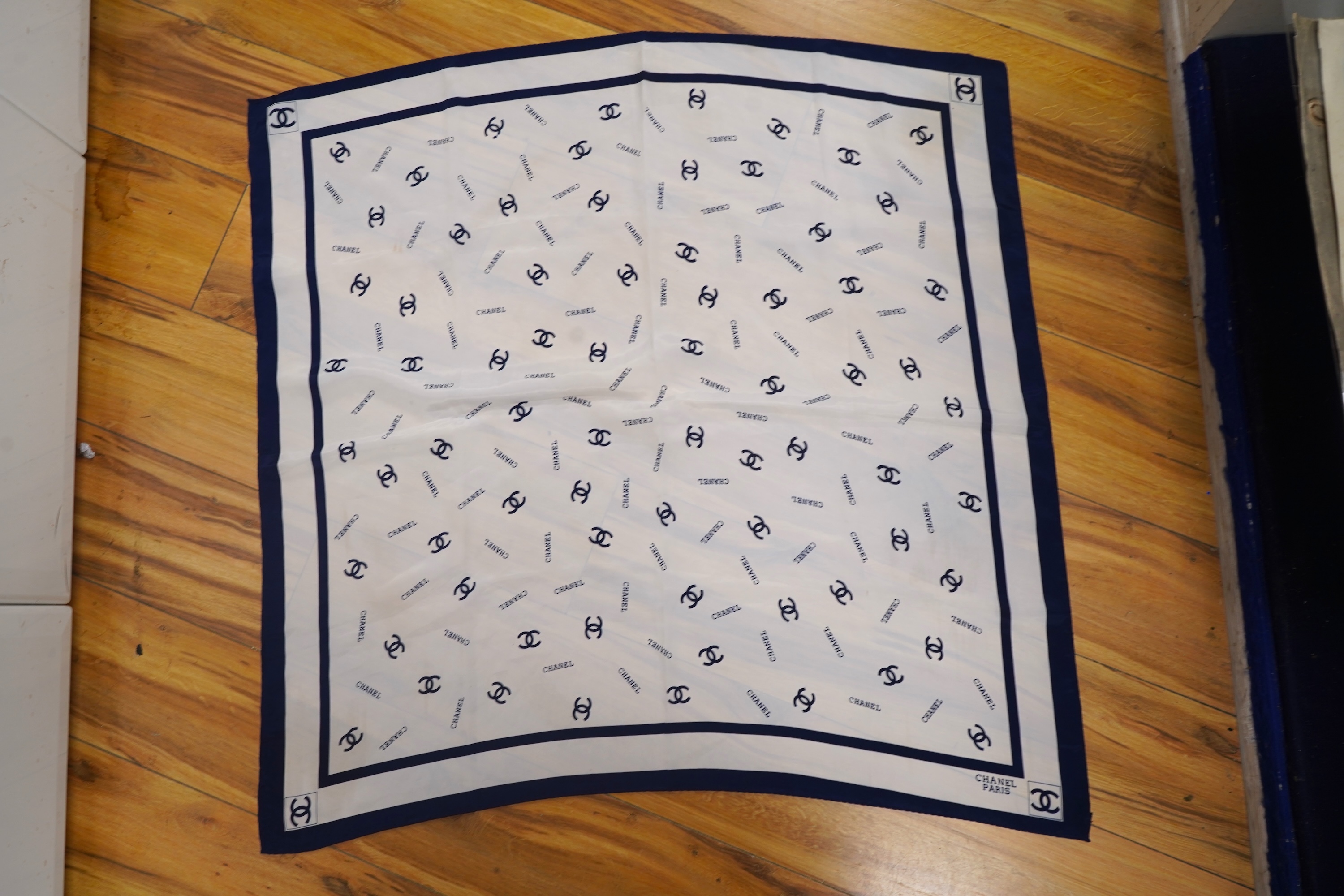 A collection of three Hermes silk scarves and a Chanel monogram example